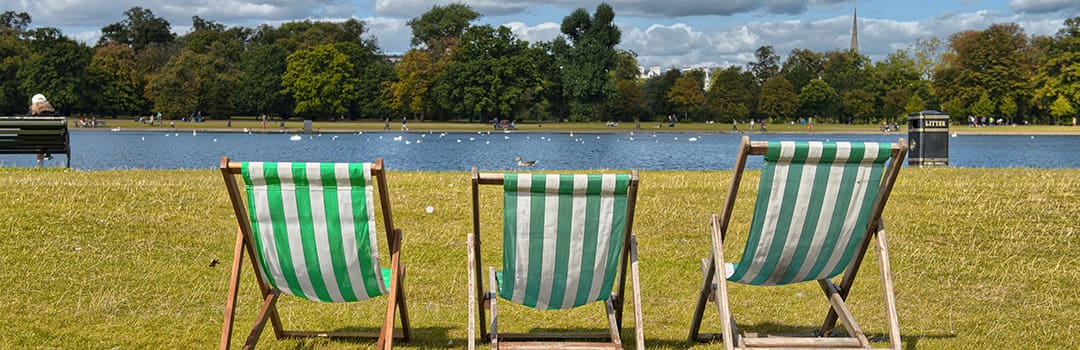 Three deckchairs by lake