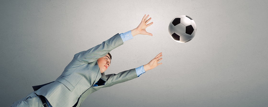 Man in suit catching football