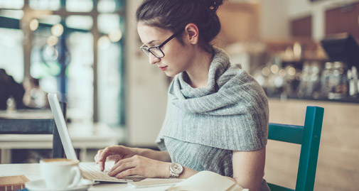 Woman at a desk looking at a laptop