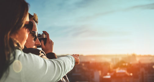 Couple taking a picture of a city with a camera