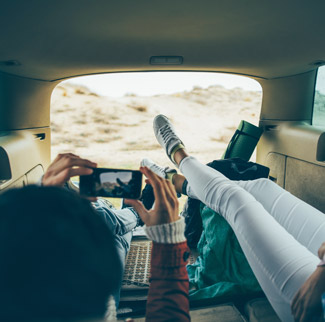 Couple taking picture in back of campervan