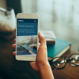 Hand holding smartphone with mobile services on screen