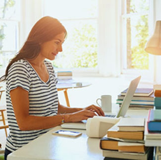 Woman at a desk looking at a laptop