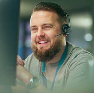 Man with telephone ear piece looking at screen