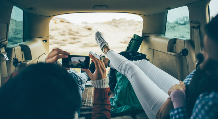 Couple taking picture in back of campervan