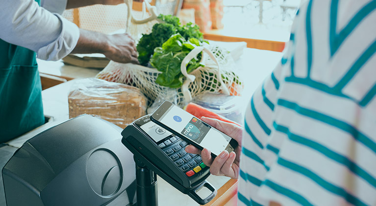Woman making contactless transaction with smartphone