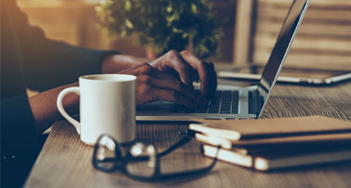 Man sat at a desk using his laptop
