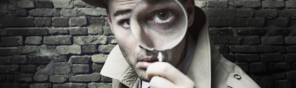 Man holding magnifying glass up to his eye