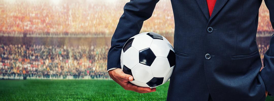 Man in suit holding a football