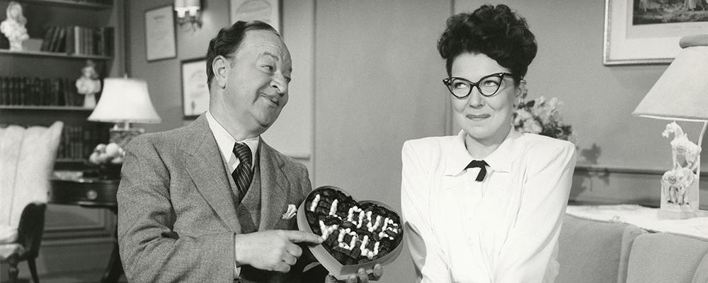 1940's couple holding chocolates saying 'I love you