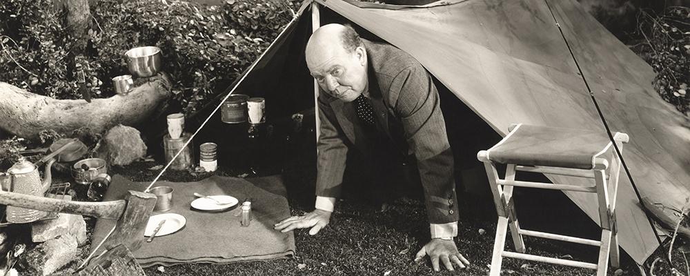 1940's man wearing suit climbing out of tent