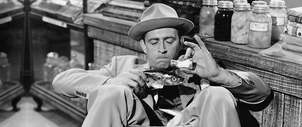 1940's man pouring salt onto a fish