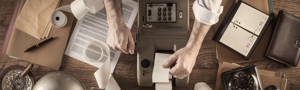 Man working at desk with vintage reciept machine