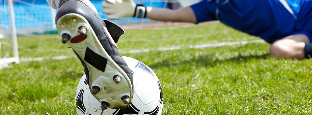 Close up of football boot kicking a football