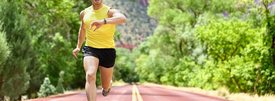 Man running checking fitness tracker on wrist